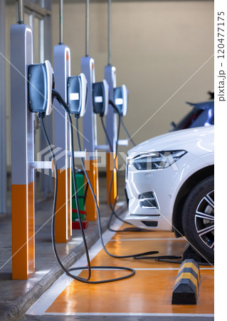 EV charger and electric car, Electric car charger station for charge ev battery, Plug for vehicle with electric engine, EV charger clean energy, Charging point at car parking lot department store. EV charger and electric car, Electric car charger station for charge ev battery, Plug for vehicle with electric engine, EV charger clean energy, Charging point at car parking lot department store. 120477175