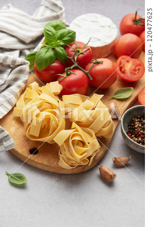 Fresh pasta, tomatoes, garlic, cheese, and basil preparing for delicious meal 120477625
