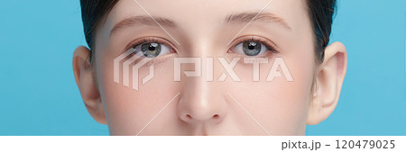 CloseUp of Woman's Blue Eyes With Natural Makeup on blue background, 120479025