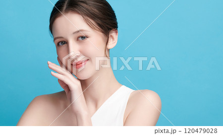 Beautiful young woman with clean fresh skin on blue background, Face care, Facial treatment, Cosmetology, beauty and spa, women portrait. Beautiful young woman with clean fresh skin on blue background, Face care, Facial treatment, Cosmetology, beauty and spa, women portrait. 120479028