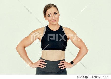 Fitness Trainer with Hands on Hips and Curious Expression. 120479357