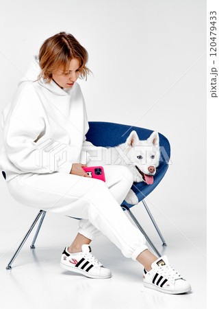 Woman and White Husky Sitting Together on Chair Woman and White Husky Sitting Together on Chair 120479433
