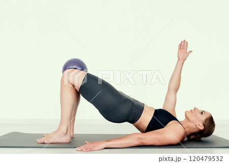 Fitness Trainer in Elevated Glute Bridge with Arm Raise Fitness Trainer in Elevated Glute Bridge with Arm Raise 120479532