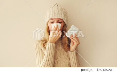 Sick exhausted woman sneezing blow nose using tissue holding pills, unhealthy girl feels unwell Sick exhausted woman sneezing blow nose using tissue holding pills, unhealthy girl feels unwell 120480281