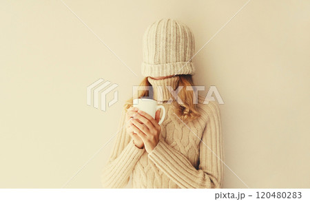 Happy funny young woman with cup of coffee drink in winter hat, sweater having fun on background Happy funny young woman with cup of coffee drink in winter hat, sweater having fun on background 120480283