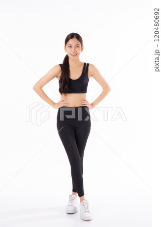 Portrait of beautiful young asian woman in sportwear smile and showing waist and abs isolated. 120480692