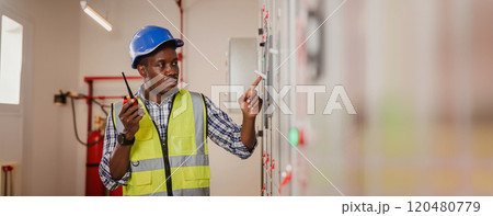 Electrical engineer working in control room. Electrical engineer man checking Power Distribution Cabinet in the control room Electrical engineer working in control room. Electrical engineer man checking Power Distribution Cabinet in the control room 120480779