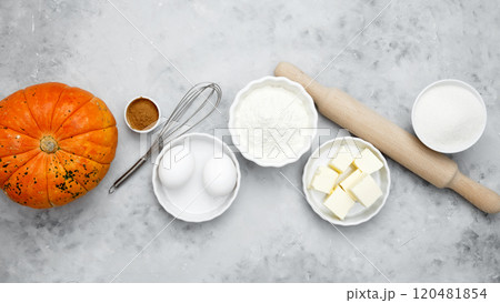 Baking ingredients including flour, butter, sugar, spices, eggs and pumpkin arranged on a gray background. Seasonal autumn baking Baking ingredients including flour, butter, sugar, spices, eggs and pumpkin arranged on a gray background. Seasonal autumn baking 120481854