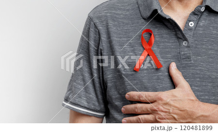 World AIDS Day. Man wears red AIDS awareness ribbon 120481899