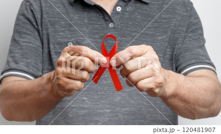 World AIDS Day. Man holding red AIDS awareness ribbon World AIDS Day. Man holding red AIDS awareness ribbon 120481907