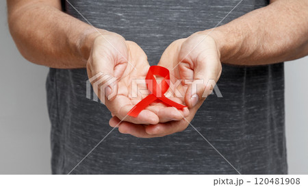 World AIDS Day. Man holding red AIDS awareness ribbon 120481908