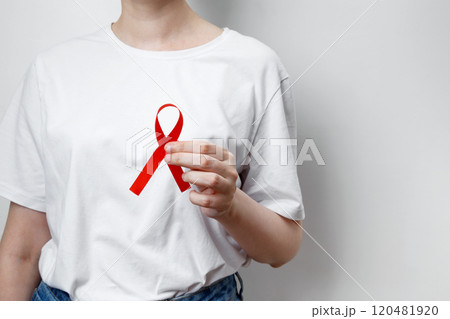 Woman holding red AIDS awareness ribbon. World AIDS Day 120481920