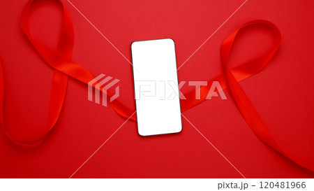 World AIDS Day. Red ribbon with AIDS awareness and a smartphone for mock up World AIDS Day. Red ribbon with AIDS awareness and a smartphone for mock up 120481966