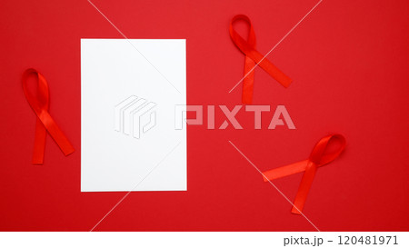 World AIDS Day. Red ribbons with awareness about AIDS and paper for mock up World AIDS Day. Red ribbons with awareness about AIDS and paper for mock up 120481971
