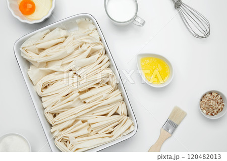 Filo dough in a baking dish near Crinkle Cake butter for buttering 120482013