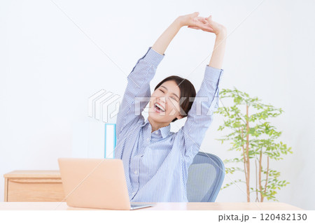 パソコンで仕事するストレッチする女性 120482130