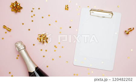 Concept of festive birthday celebrations. Blank card surrounded by confetti and bottle of champagne 120482202