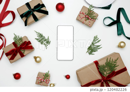 Christmas gifts wrapped with decorative elements, and smartphone mockup on display 120482226