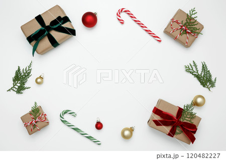 Wrapped Christmas gifts with green thuja branches creating a festive, natural holiday scene Wrapped Christmas gifts with green thuja branches creating a festive, natural holiday scene 120482227