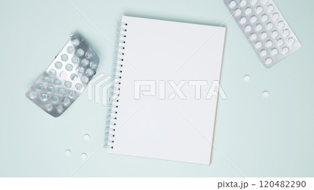 Concept of medicine, healthcare, and pharmaceutical industry. Blister of tablets with pills and blank notebook 120482290