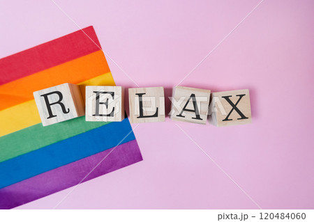 Rainbow flag and a wooden block with the word relax written on it Rainbow flag and a wooden block with the word relax written on it 120484060