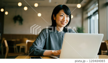 カフェでノートパソコンを操作する40代の女性 120484065