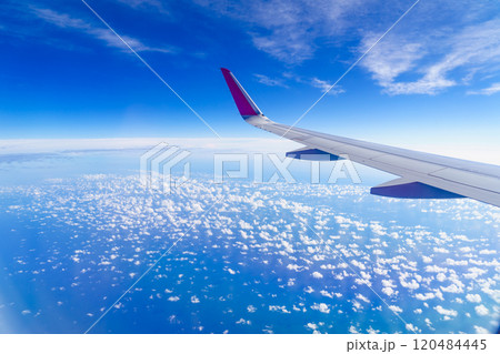 View from an airplane window to wing and clouds View from an airplane window to wing and clouds 120484445