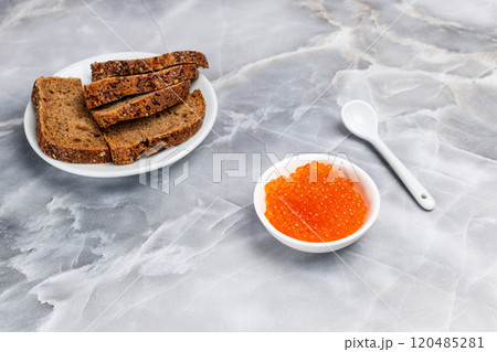 Red salmon caviar and rye bread on the kitchen table. Red salmon caviar and rye bread on the kitchen table. 120485281