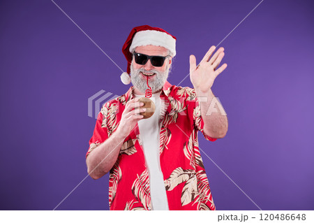 Waving Senior Man in Santa Hat Holding Pineapple Drink Waving Senior Man in Santa Hat Holding Pineapple Drink 120486648