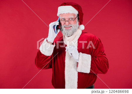 Smiling Man Wearing Santa Costume Using Smartphone Smiling Man Wearing Santa Costume Using Smartphone 120486698