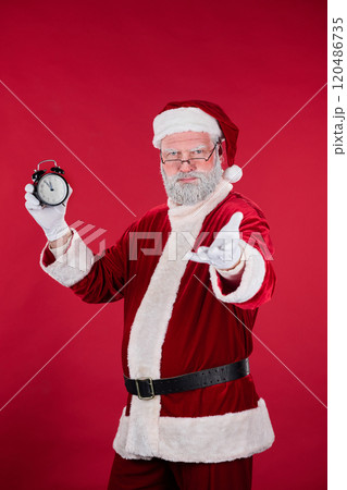 Santa Claus Holding Clock in Festive Red Background Santa Claus Holding Clock in Festive Red Background 120486735