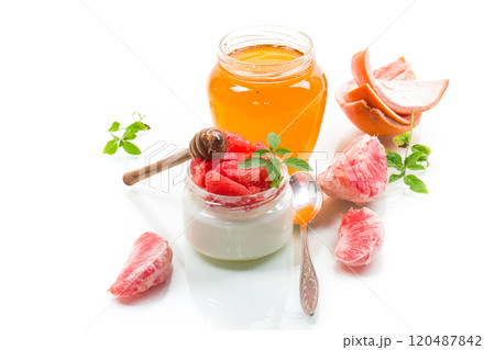 homemade sweet yogurt in a glass jar with pieces of red ripe grapefruit and honey, isolated on white background homemade sweet yogurt in a glass jar with pieces of red ripe grapefruit and honey, isolated on white background 120487842