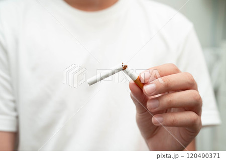 Quit smoking, Asian teenage man breaking destroy cigarette in hand. 120490371