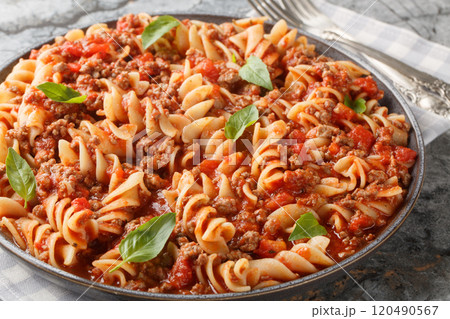 Italian Fusilloni Pasta with ground meat, tomato sauce and vegetables closeup on the plate. Horizontal 120490567