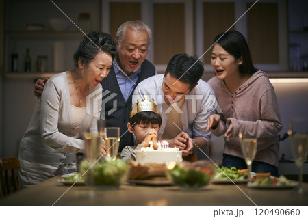 three generation asian family celebrating little boy's birthday at home 120490660