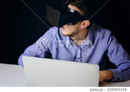 A person uses virtual reality on a laptop, blending technology with productivity and innovation in a modern workspace 120491244