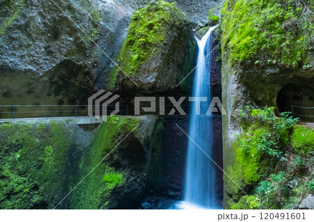 Levada Nova and Levada do Moinho in Madeira. Beautiful hiking path next to the levadas with waterfalls and tunnels Levada Nova and Levada do Moinho in Madeira. Beautiful hiking path next to the levadas with waterfalls and tunnels 120491601