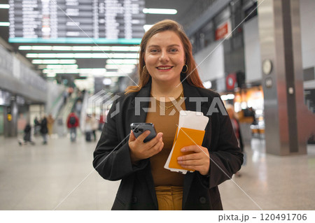 Portrait of positive cheerful traveler woman hold ticket ready enjoy voyage tour passenger walk in airport terminal to boarding gate. Attractive beautiful female tourist excited to go travel abroad by 120491706