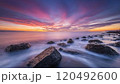 a rocky shoreline at sunset 120492600