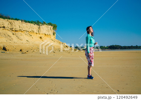 a young woman in a floral dress in the desert with yellow sand near Larnaca, Cyprus a young woman in a floral dress in the desert with yellow sand near Larnaca, Cyprus 120492649