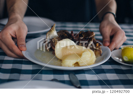 a young man enjoys a meal in a Greek restaurant 120492700