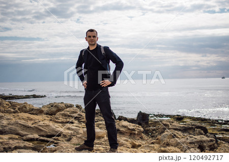 young man with a backpack on the seashore 120492717