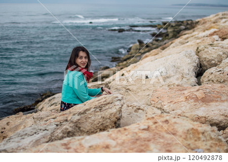portrait of a young woman in bright clothes on the rocky coast of Ayia Napa, Cyprus 120492878