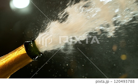 Freeze motion of Champagne explosion with flying cork closure, opening champagne bottle closeup. 120493788