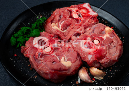 raw steak, calf's neck on the bone, fresh meat, on a black plate, top view, no people, raw steak, calf's neck on the bone, fresh meat, on a black plate, top view, no people, 120493961
