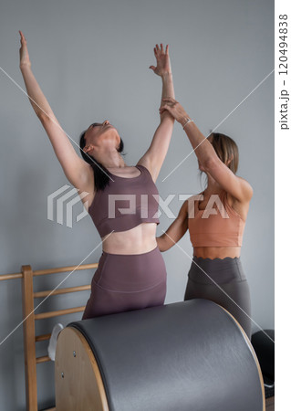 Portrait of woman with pilates trainer doing exersices on the Ladder Barrel. Pilates equipment. Pilates studio machine for fitness workouts in gym. Fit, healthy and strong authentical body. 120494838