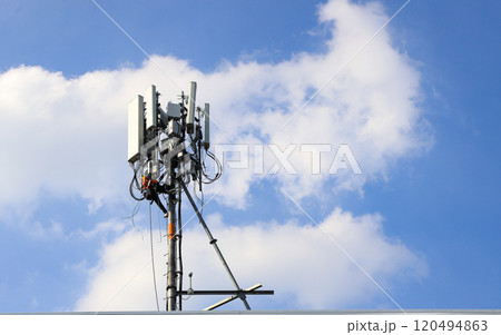 Technician maintenance Wireless Communication Antenna pole or Mobile phone mast antenna pole on top of dilapidated building. 120494863
