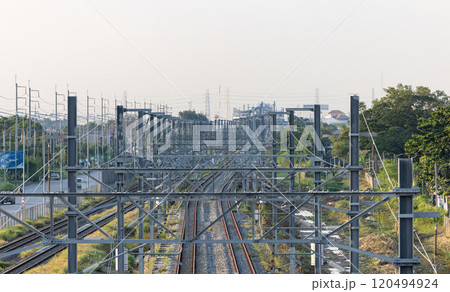 Aerial view of Infrastructure of railway tracks equipped with overhead electric poles in parallel to high powered supply lines in suburban. Aerial view of Infrastructure of railway tracks equipped with overhead electric poles in parallel to high powered supply lines in suburban. 120494924