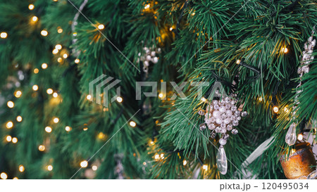 Decorated Christmas tree branch with wooden ornament and warm lights background Decorated Christmas tree branch with wooden ornament and warm lights background 120495034
