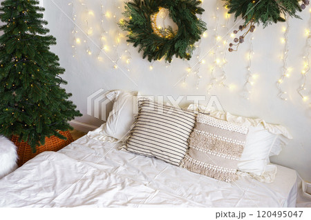Christmas tree and wreath in bedroom, holiday decor and warm lighting during winter months 120495047